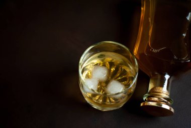 Siyah arka planda buz küpleri ve viski şişesi ile viski Bir bardak 