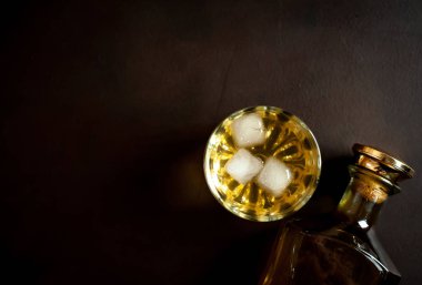 Siyah arka planda buz küpleri ve viski şişesi ile viski Bir bardak 
