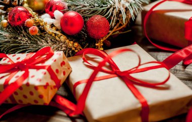 Eski ahşap arka plan üzerinde dekor ile kırmızı yay ve köknar çelenk ile hediye kutuları Yığını 