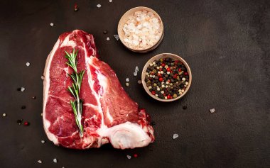 Biberiye dal, tuz ve biberiye siyah taş arka plan taze domuz biftek 