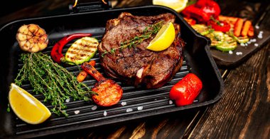 Izgara tavada biberiye ve sebze ile Taze ızgara domuz biftek 