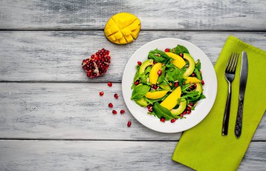 Arugula, ıspanak, dilimlenmiş mango ve avokado, nar ve ayçiçeği tohumu ile taze vegan salata