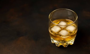 Siyah arka planda bir bardak buz viskisi