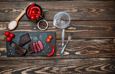 kahverengi ahşap masa üzerinde ahşap tahta üzerinde kiraz domates ve biber ile taze ızgara sığır biftek