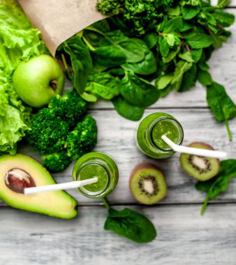 Gri arka planda sebze ve meyve ile Taze yeşil smoothie