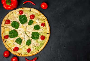siyah taş arka plan üzerinde kiraz domates ve taze ıspanak yaprakları ile pizza