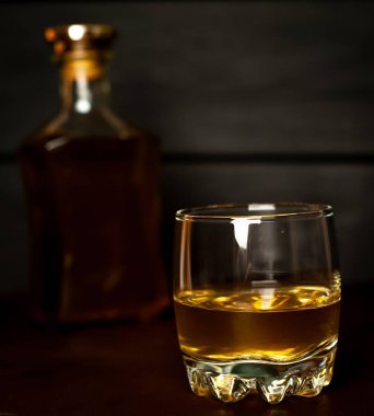 Siyah arka planda buz küpleri ve viski şişesi ile viski Bir bardak 