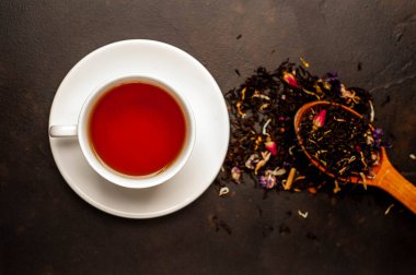 siyah arka plan üzerinde çiçek demlemek yığını ile taze çay fincan