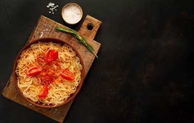 ahşap doğrama tahtası üzerinde domates sosu ve biberiye ile İtalyan spagetti makarna 