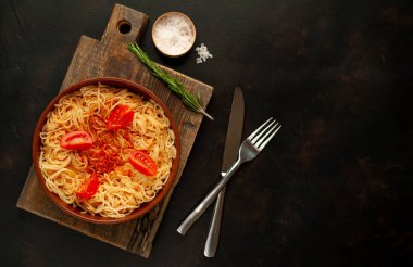 ahşap doğrama tahtası üzerinde domates sosu ve biberiye ile İtalyan spagetti makarna 