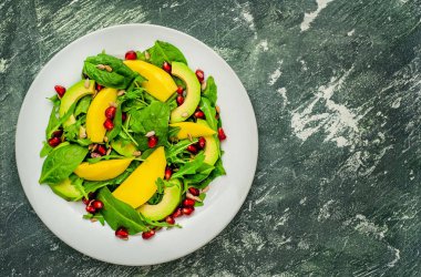 Arugula, ıspanak, dilimlenmiş mango ve avokado, nar ve ayçiçeği tohumu ile taze vegan salata