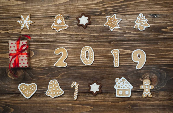 Collection of homemade christmas cookies with gift on wooden background