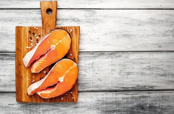 Ahşap doğrama tahtası üzerinde baharat ile taze çiğ somon biftek