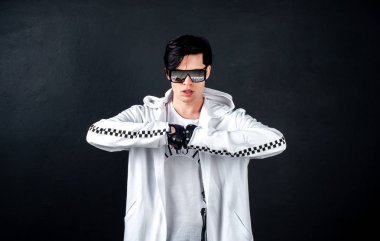 Siyah arka planda poz veren şık esmer bir adam.