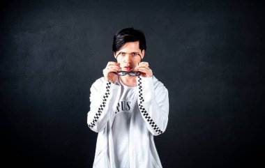 Siyah arka planda poz veren şık esmer bir adam.