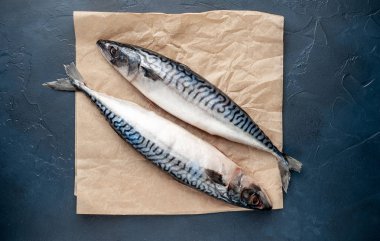 Siyah taş arka plan üzerinde zanaat kağıt üzerinde çiğ taze balık 