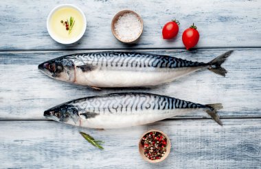 Gri ahşap arka plan üzerinde biberiye dalları ile çiğ balık