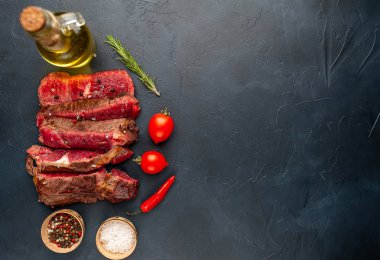 Siyah taş arka plan üzerinde baharat ile taze dilimlenmiş nadir ızgara beefsteak