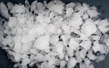 Siyah taş arka plan üzerinde ezilmiş buz yığını 