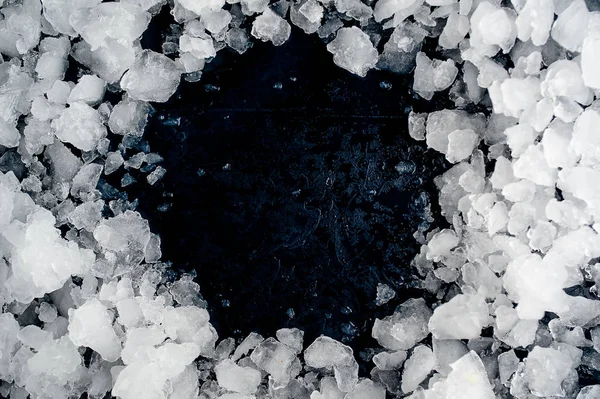 Pile of crushed ice on black stone background