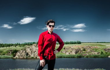 Yeşil peyzaj arka planda poz kırmızı gömlek genç şık adam