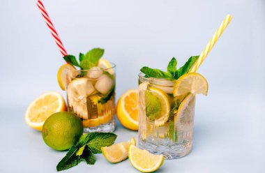 limonlimonata iki bardak, limon ve nane yaprakları, buz küpleri ve beyaz pipetler