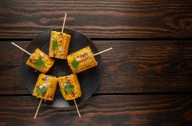 ahşap masa üzerinde tabakta tuz ile mısır ızgara parçaları