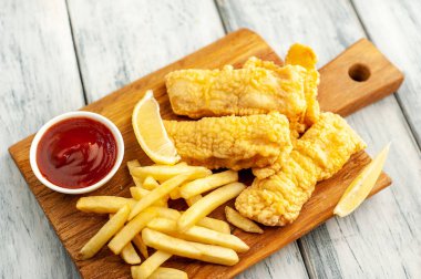 Patates kızartması ve ahşap arka planda kızarmış tavuk nugget. 