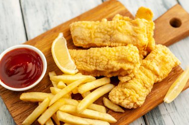 Patates kızartması ve ahşap arka planda kızarmış tavuk nugget. 