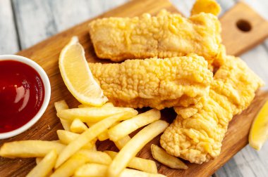 Patates kızartması ve ahşap arka planda kızarmış tavuk nugget. 