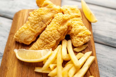 Patates kızartması ve ahşap arka planda kızarmış tavuk nugget. 