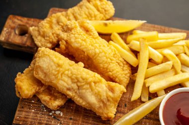 Patates kızartması ve ahşap arka planda kızarmış tavuk nugget. 