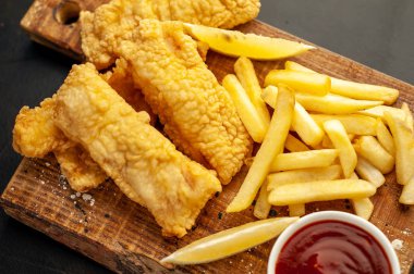 Patates kızartması ve ahşap arka planda kızarmış tavuk nugget. 