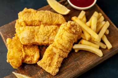 Patates kızartması ve ahşap arka planda kızarmış tavuk nugget. 