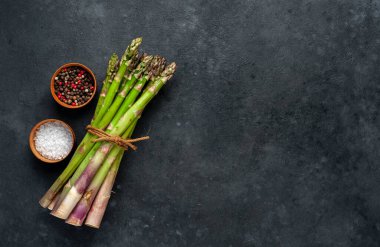 Metnin için kopyalama alanı olan bir taş zemin üzerinde çiğ yeşil kuşkonmaz.