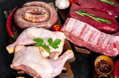 Çeşitli ızgara ve barbekü çeşitleri. Çiğ biftek, sosis, domuz kaburgası, arka planda baharat olan tavuk bacağı.