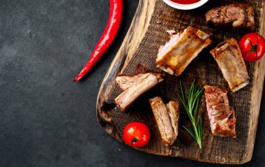 Siyah arka planda baharatlı ızgara domuz pirzolası.