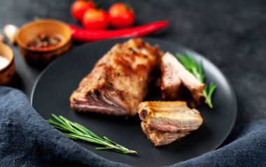 Siyah arka planda baharatlı ızgara domuz pirzolası.