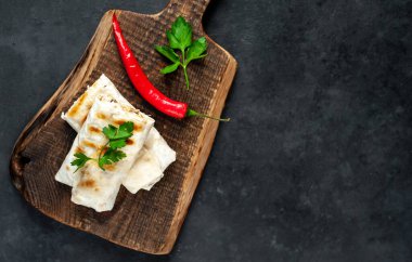 Geleneksel Meksika dürümü. Siyah arka planda baharatlı soslu tavuk ve sebzeyle sarılmış.