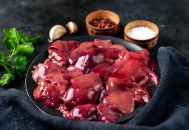 Siyah arka planda pişirmek için çiğ tavuk ciğeri.