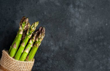 Siyah taş zemin üzerinde ham yeşil kuşkonmaz ve kopyalama alanı 