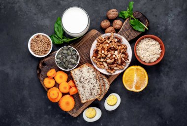 Sağlıklı gıda kavramı, siyah taş arka planda taze organik malzemeler.