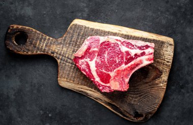 Tahta kesme tahtasında çiğ et. Koyu arkaplan