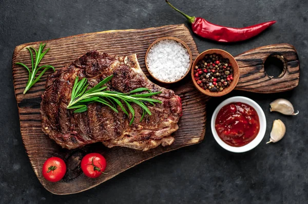 Grillezett Steak Fűszerekkel Zöldségekkel Fűszernövényekkel Fából Készült Vágódeszkán Sötét Háttérrel — Stock Fotó