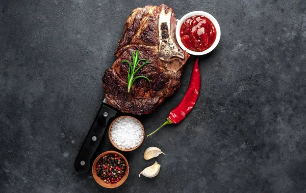 Grillezett Steak Fűszerekkel Zöldségekkel Fűszernövényekkel Vágókéssel Sötét Háttérrel — Stock Fotó