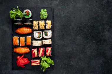 Soya sosu ve yemek çubuklarıyla sıralanmış suşi setinin üst görüntüsünü kapat.