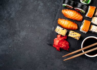 Soya sosu ve yemek çubuklarıyla hazırlanmış suşi setinin fotoğrafını kapat.