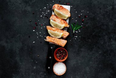 Koyu arkaplanda baharatlı ızgara somon parçaları. 