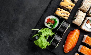 Soya sosu ve yemek çubuklarıyla hazırlanmış suşi setinin fotoğrafını kapat.