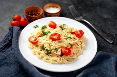 Soslu makarna tabağı, sebze ve koyu arkaplanda et.